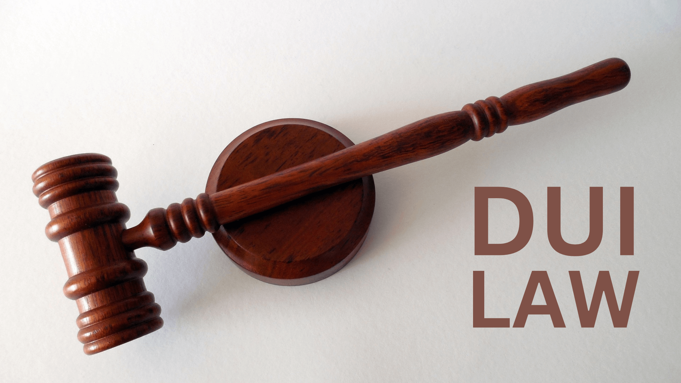 DUI law concept with a wooden gavel on a white background.