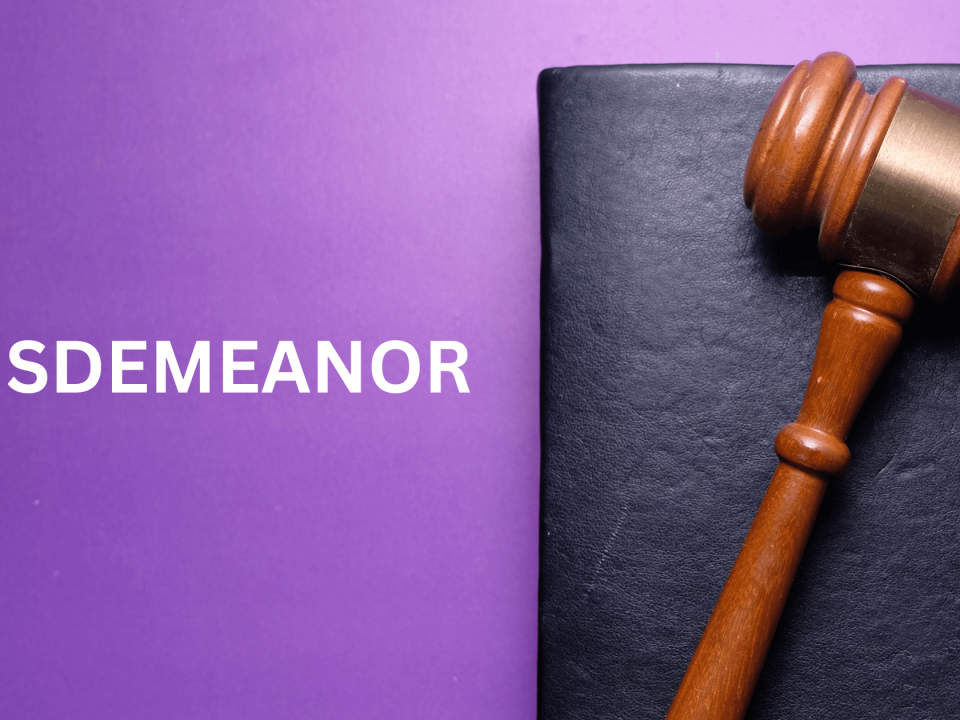 Judges gavel on dark surface with MISDEMEANOR text on purple background.