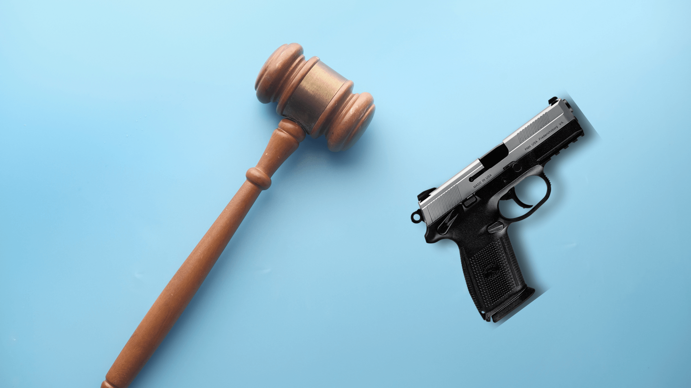 Gavel and pistol on blue background, representing law, order, and force.